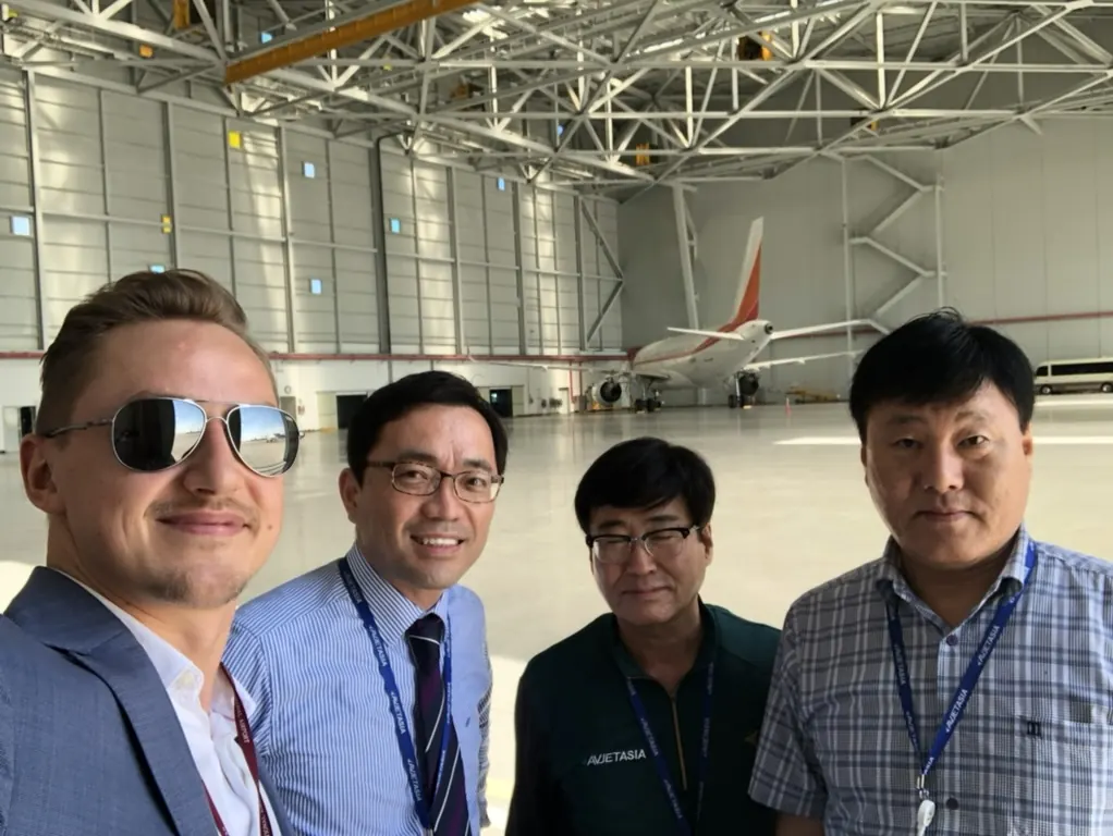 Audrius Kazlauskas at an aviation hangar with maintenance team